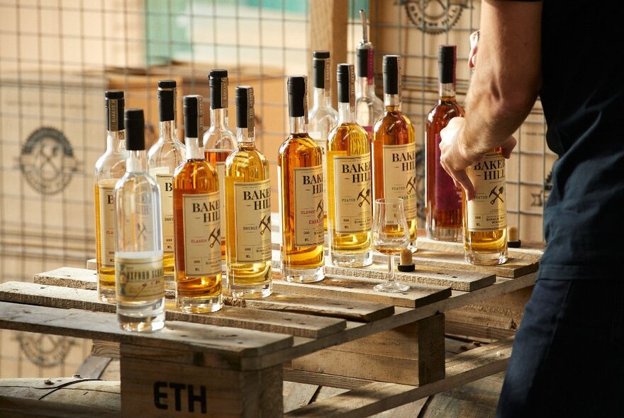 Bottles of whisky lined up on a wooden table.