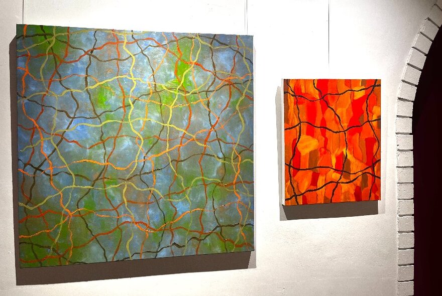 A gallery wall showing two works by artist Matthew Simpson, both a tangle of coloured lines. 