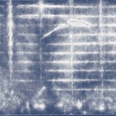 A blurry, blue and white-toned photograph of a storm drain.