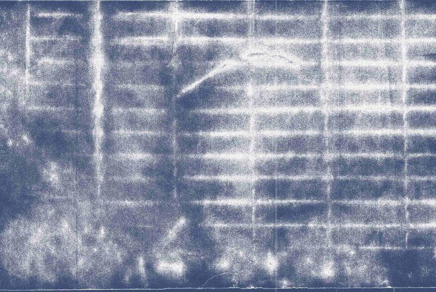 A blurry, blue and white-toned photograph of a storm drain.