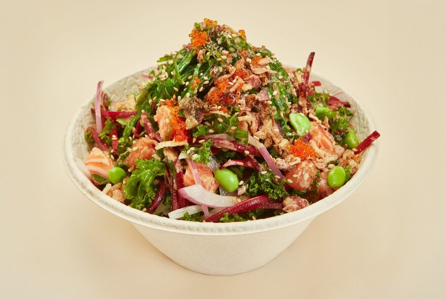 A bowl of salmon, noodles and fresh salad vegetables.