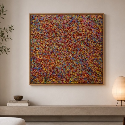 A colourful abstract painting hung on a wall above a concrete bench and next to an indoor olive tree.
