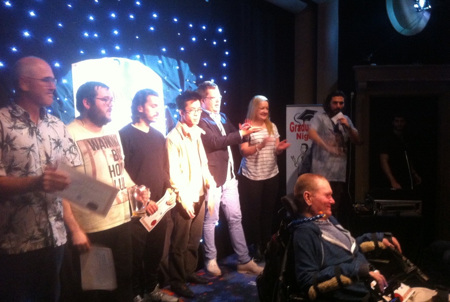 A group of people on stage at a stand-up comedy preparation course.