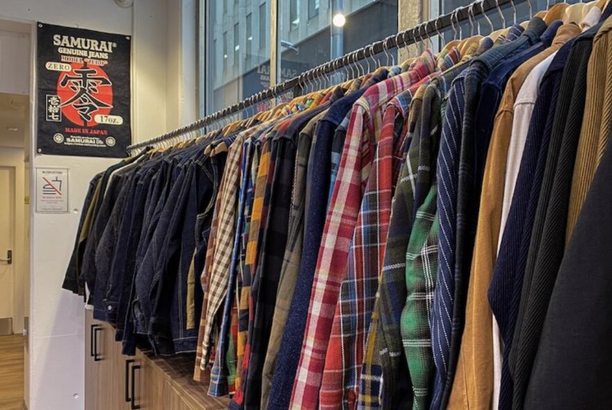 Men's shirts and jackets hanging on a rack.