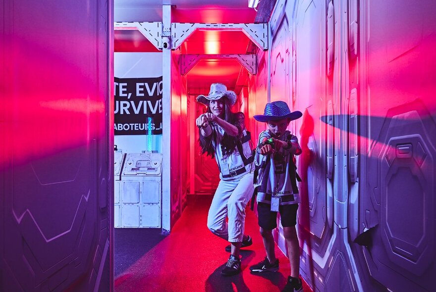 People playing an 'Among Us' style game, two crew members pointing weapons straight ahead. 