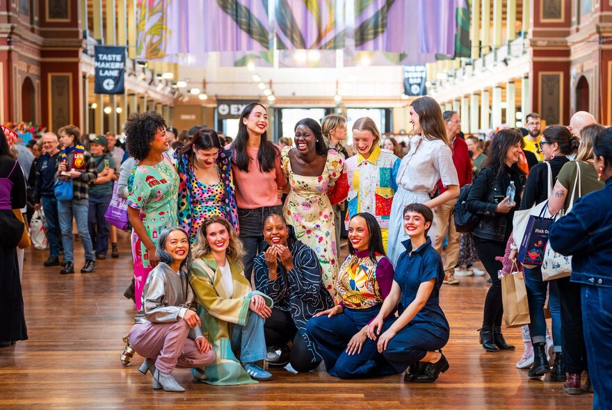 A smiling group of friends posed in a group at the Big Design Market inside the Royal Exhibition Buildings.