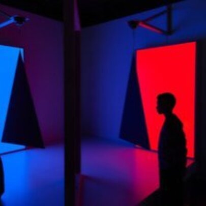 Dark silhouetted figures in a space with red and blue lighting.