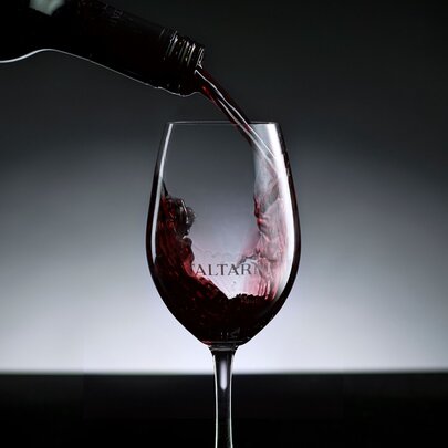 Red wine being poured from a bottle into a wine glass.