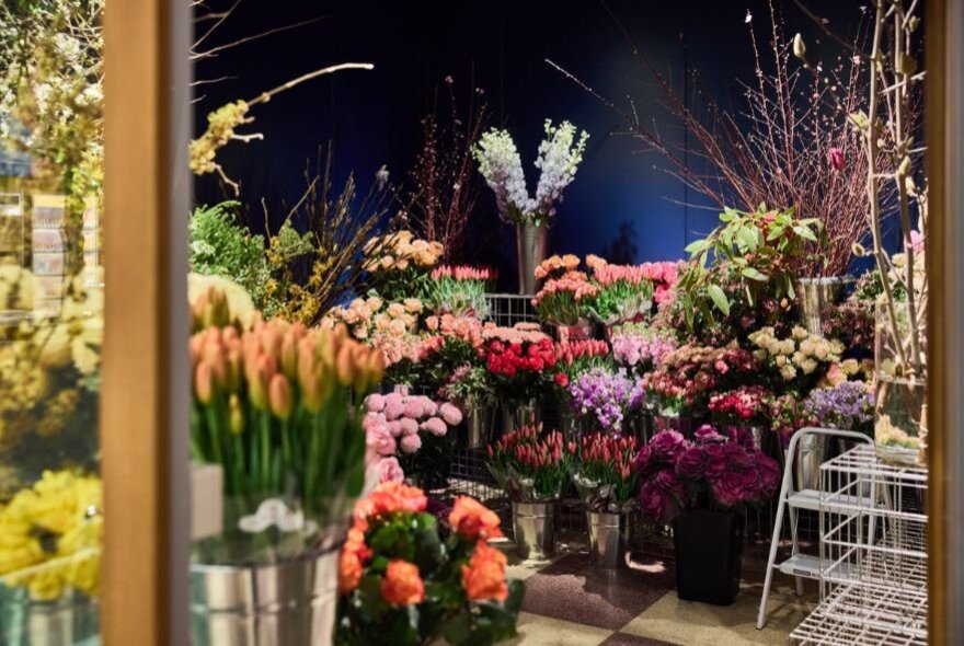 BUckets of tulips and other flowers in a florist.