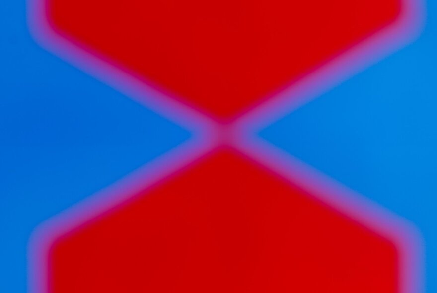 Graphic two-coloured artwork with red arrow shapes with blue background.