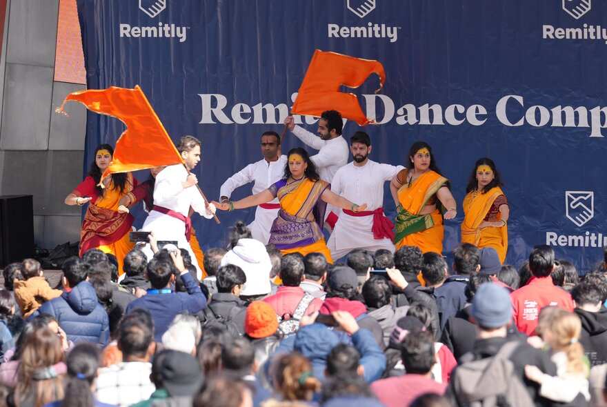 People dancing on stage at an Indian festival.