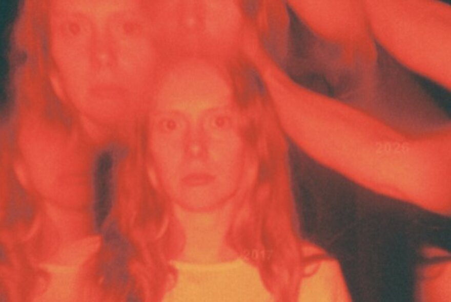 Blurred multiple image of a woman with blonde hair looking forward.