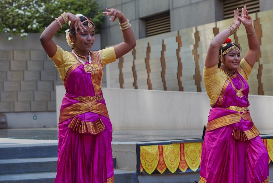 Two classical Indian dancers performing a traditional dance in a foyer or outdoor area, as part of Diwali celebrations.
