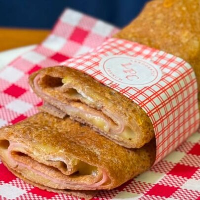 A galette, cut in half and stacked together, on a red and white checked napkin. 