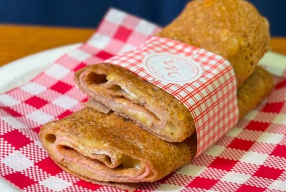 A galette, cut in half and stacked together, on a red and white checked napkin. 