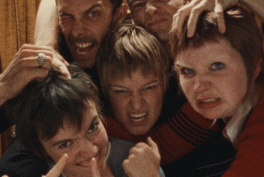 Five young actors with sharpie haircuts grimacing at the camera.