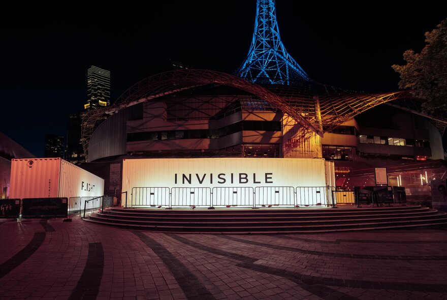 Theatrically lit podium in front of the Arts Centre  spire at night.