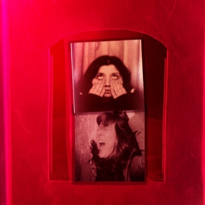 Photo booth images of a girl screaming and pulling a face with a red background.