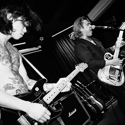 Band performing live on a stage; black and white image.