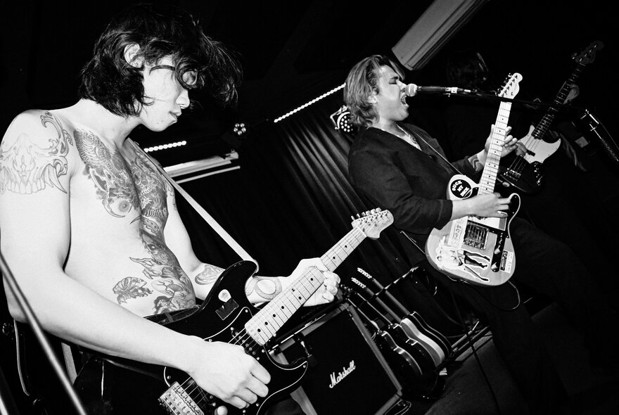 Band performing live on a stage; black and white image.
