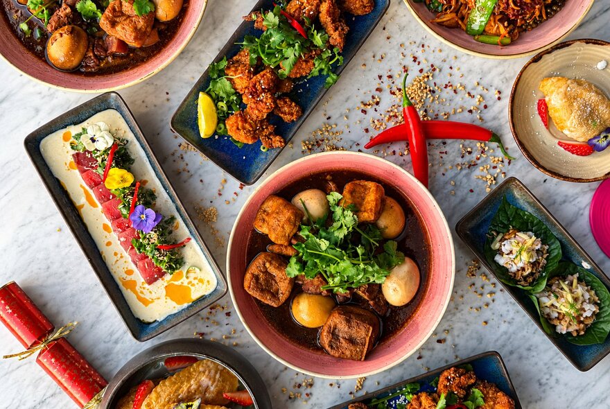 Dishes of food with crackers on a dining table.