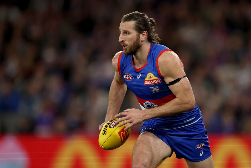 Marcus Bontempelli from the Western Bulldogs runs with a yellow football at a match. 