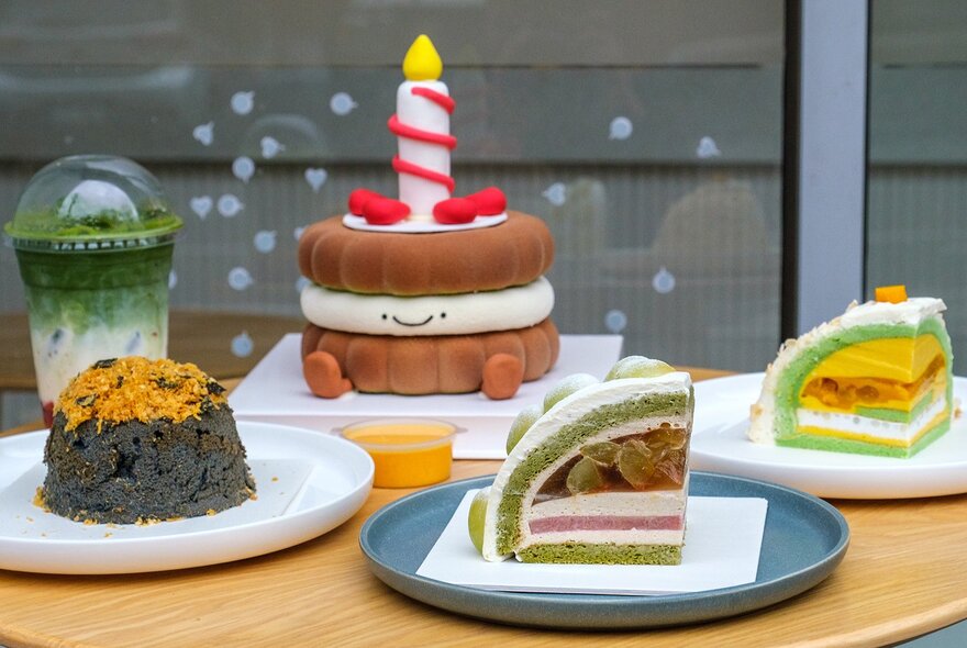 Colourful cakes including one with a candle, legs and smiley face.