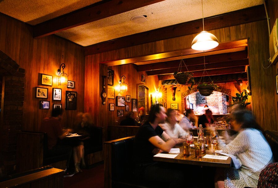A busy and dimly lit restaurant with timber walls.