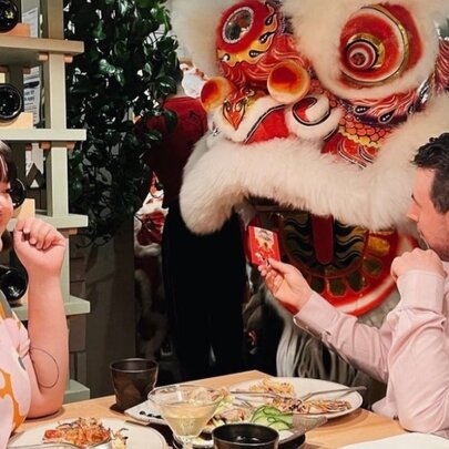 Two diners at a restaurant watching a traditional Chinese lion dance performance. 