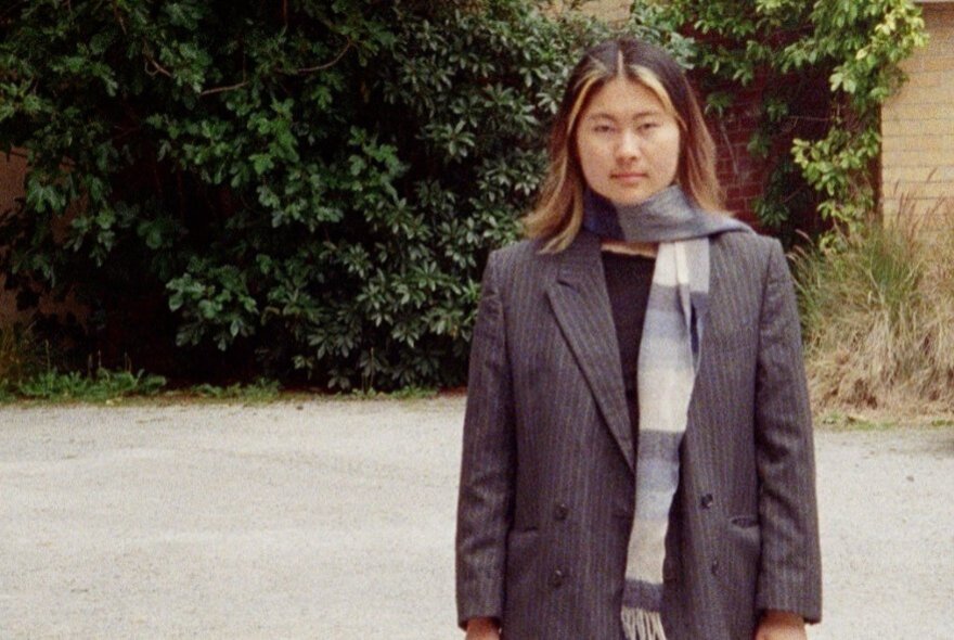 Writer Lucy Fan Xu, standing outdoors wearing a long coat and scarf.