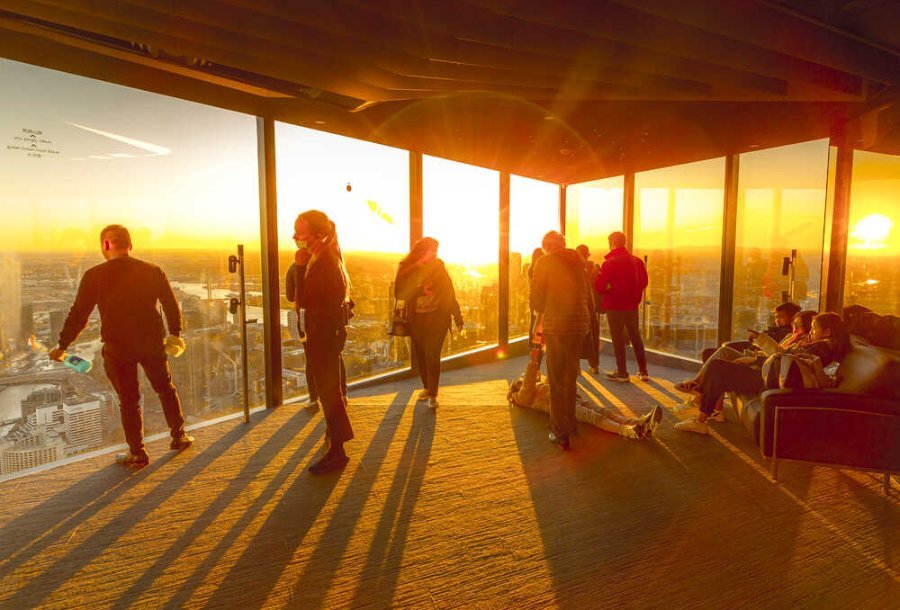 People standing on an observation deck at sunset.