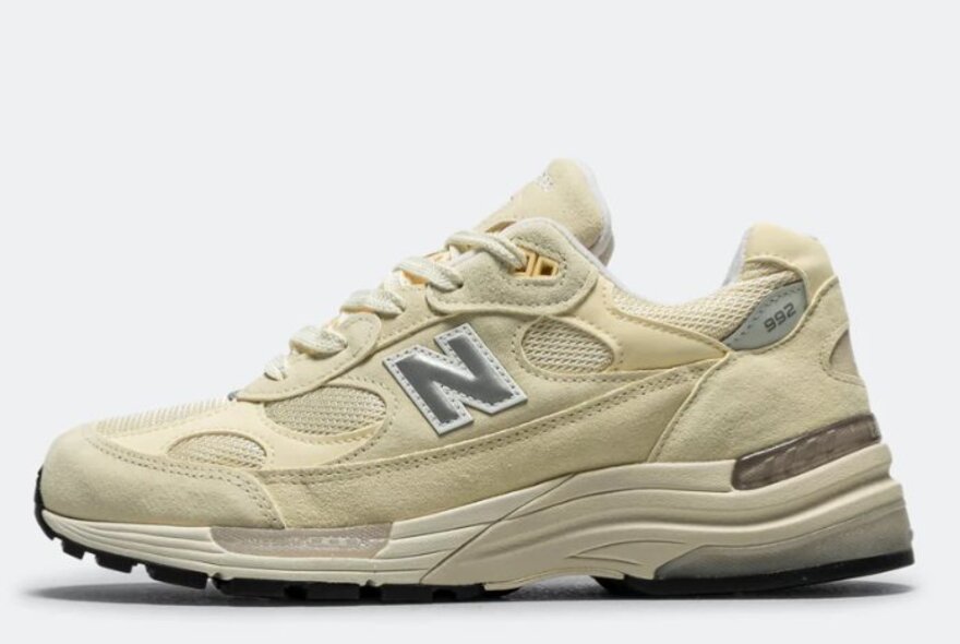 A beige and yellow sneaker with an N logo.