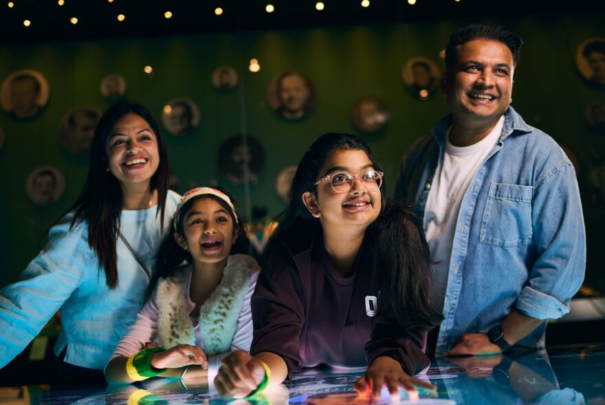A family smiling as they interact with a digital tabletop.