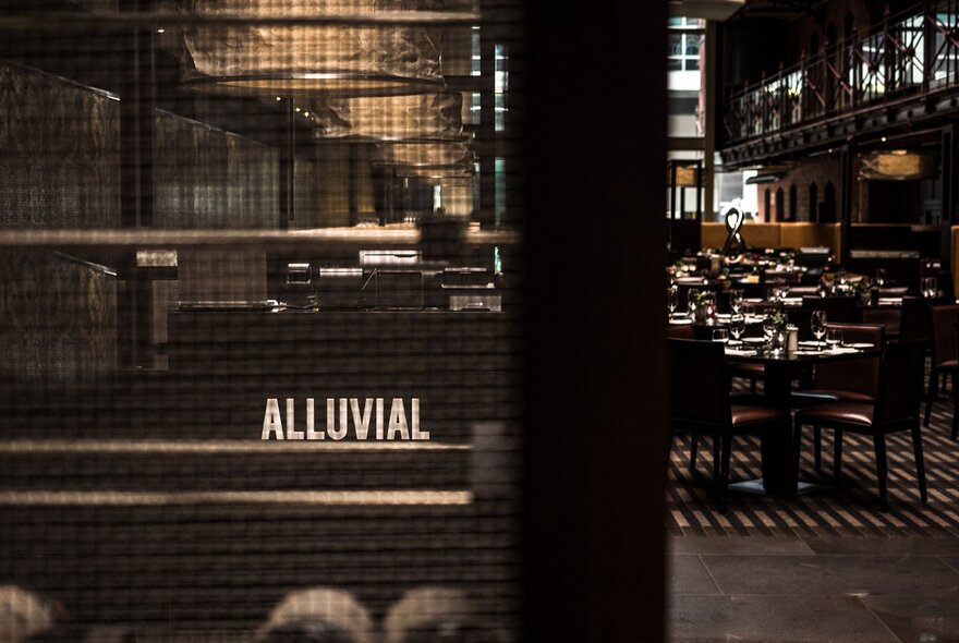 Looking into Alluvial restaurant, with a glimpse of tables and chairs set for a dining service.