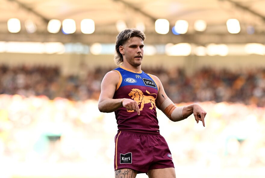 A Brisbane Lions AFL player celebrating a goal during a game.