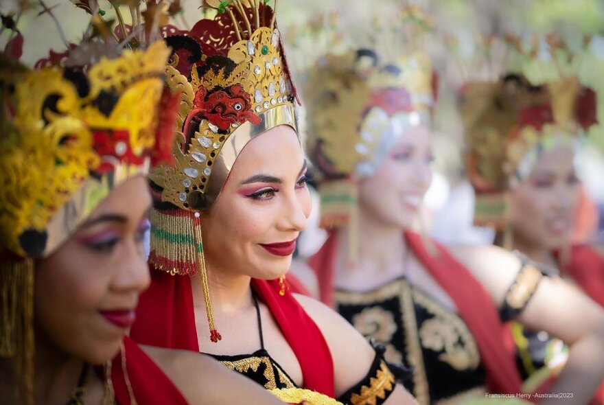 Indonesian dancers wearing headdresses and costumes.