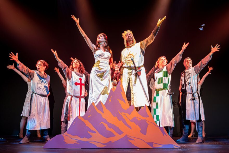Actors performing on stage dressed as medieval knights.
