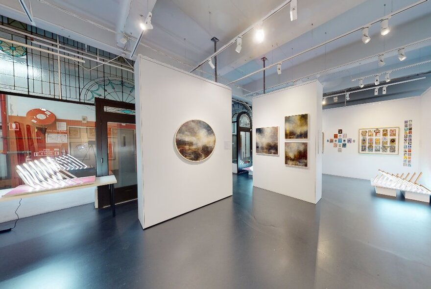 Spacious interior of Flinders Lane Gallery with artworks of varied sizes hanging on the white walls.