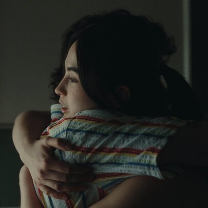 A still from the film, Dodger, showing two people hugging.