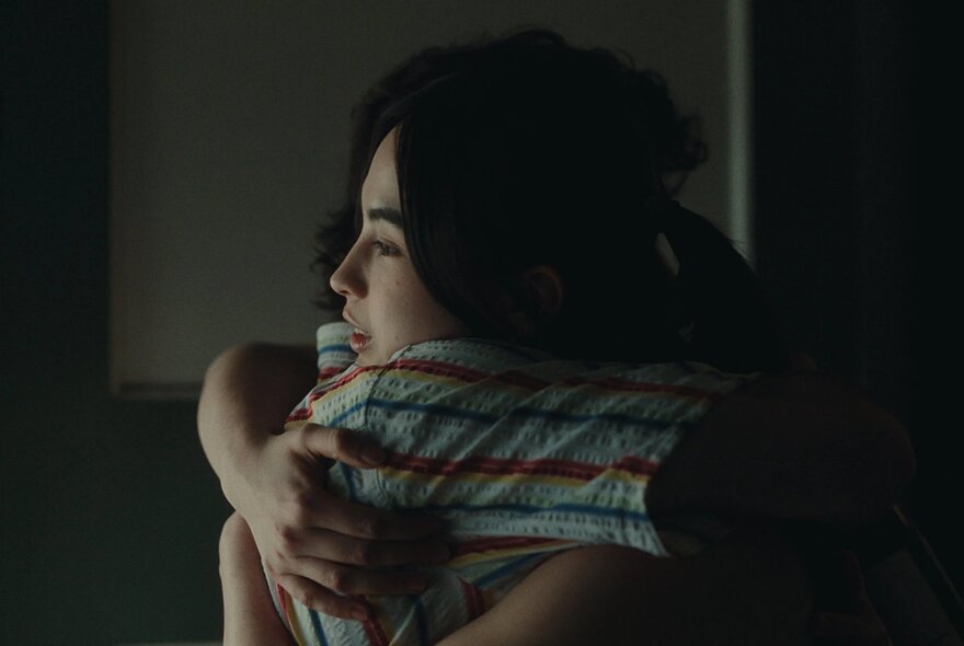 A still from the film, Dodger, showing two people hugging.