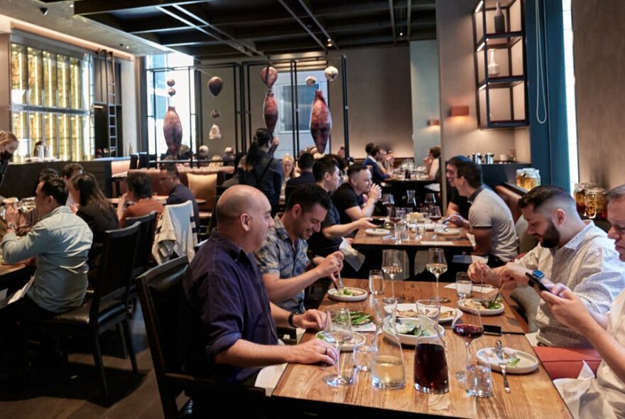 People eating and drinking at tables inside La Madonna restaurant.