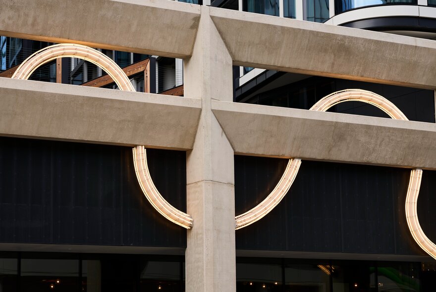 Detail of a public artwork with horizontal beams and curved metal.