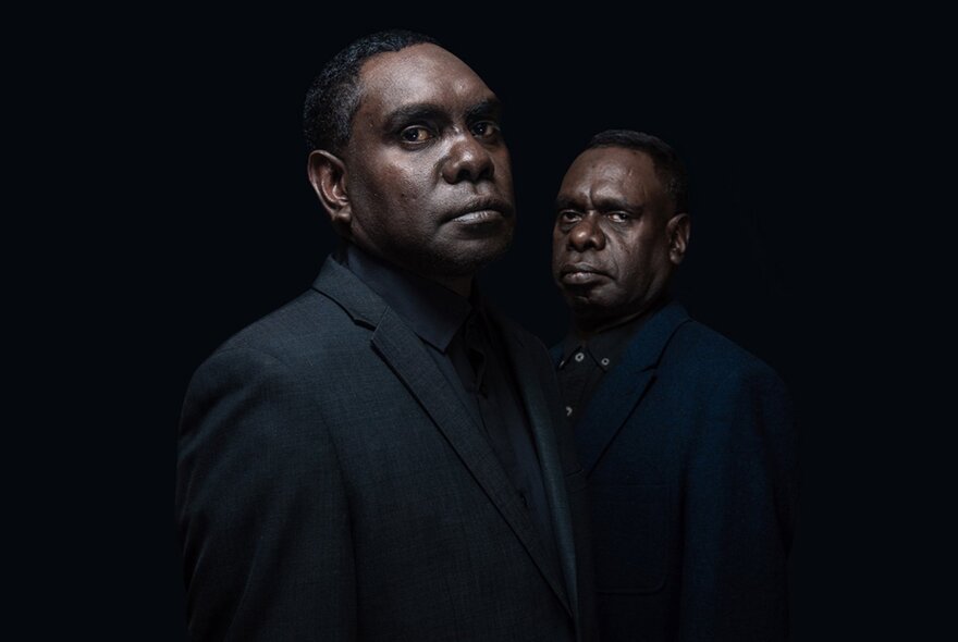 Yolnu songmen, Daniel and David Wilfred looking serious in a dark room.