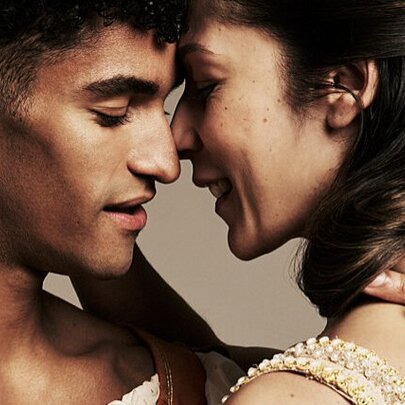 A couple about to kiss, smiling.