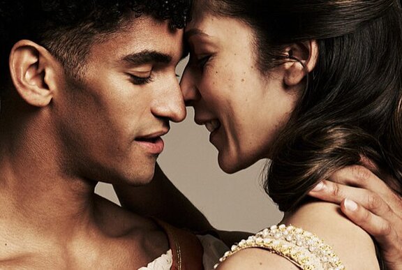A couple about to kiss, smiling.