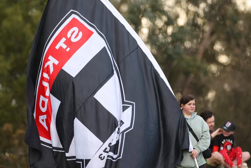 AFL football fan with large St Kilda flag.
