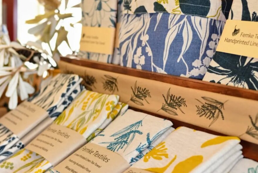 Folded textiles as part of a retail display inside a shop.