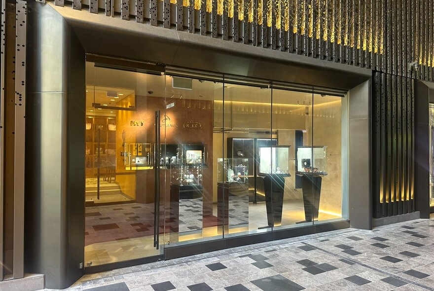 Shopfront viewed from tiled foyer with window displays.