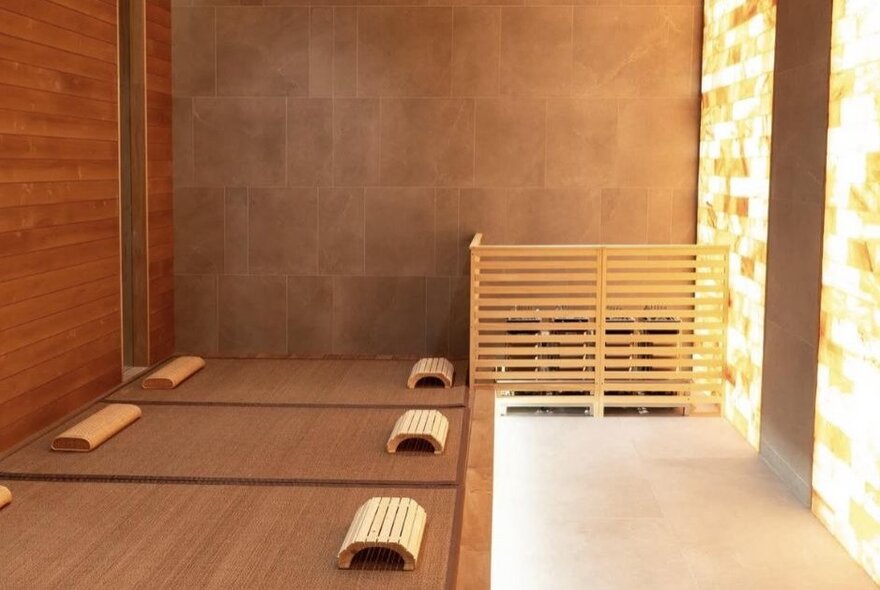 A wooden room with benches and glowing salt lamps, likely a sauna, massage or steam room.