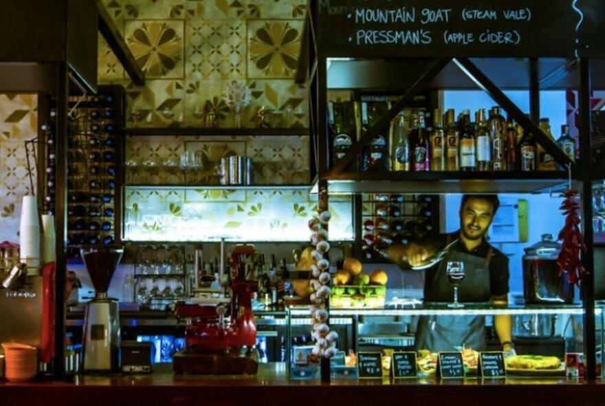 Barman pouring a glass of wine.